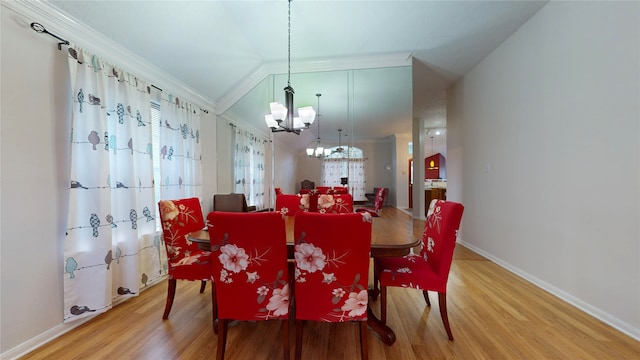 dining space with ornamental molding, wood-type flooring, and an inviting chandelier