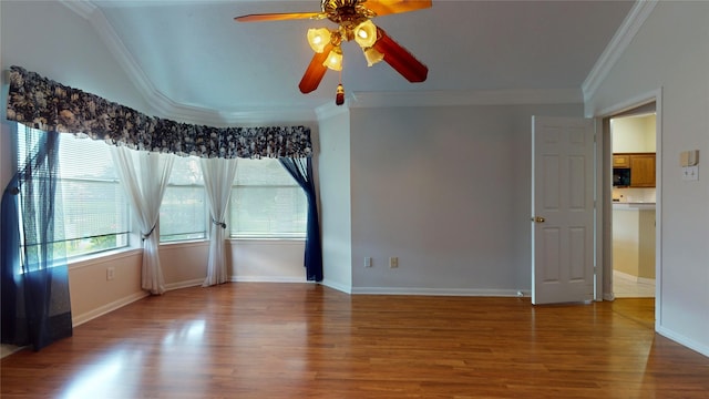 empty room featuring ceiling fan, hardwood / wood-style flooring, and crown molding