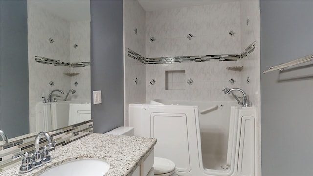 bathroom featuring vanity, decorative backsplash, toilet, and a washtub