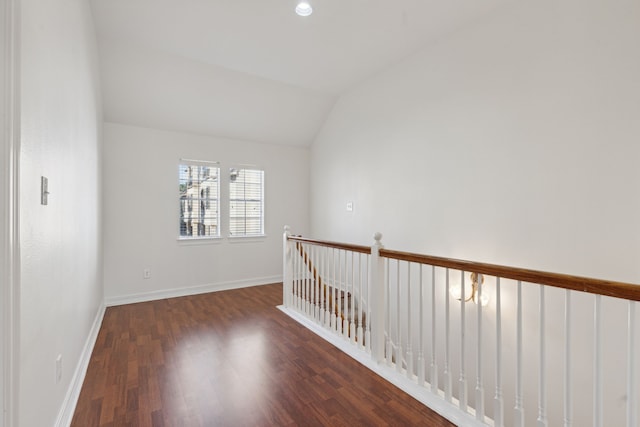 spare room featuring lofted ceiling and dark hardwood / wood-style flooring