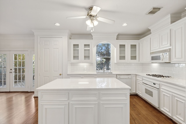 kitchen featuring white appliances, white cabinetry, a center island, and dark hardwood / wood-style floors