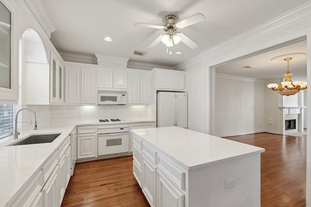 kitchen with white cabinets, white appliances, dark hardwood / wood-style floors, and sink