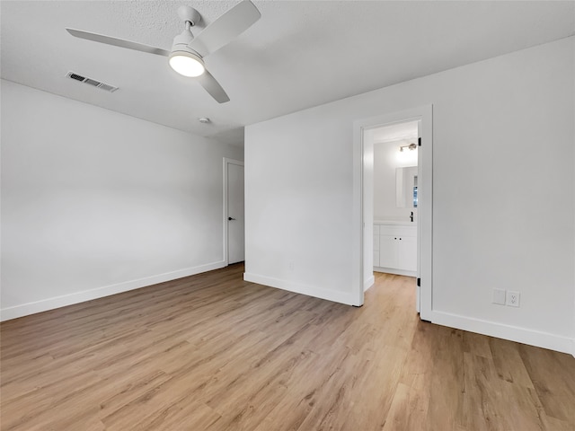 empty room featuring light hardwood / wood-style flooring, ceiling fan, and a textured ceiling