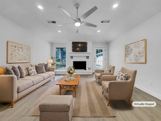 living room featuring ceiling fan, wood-type flooring, and a healthy amount of sunlight