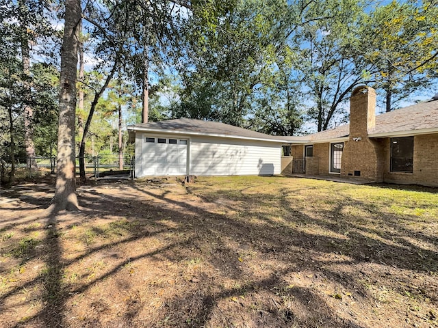 back of property with a yard and a garage