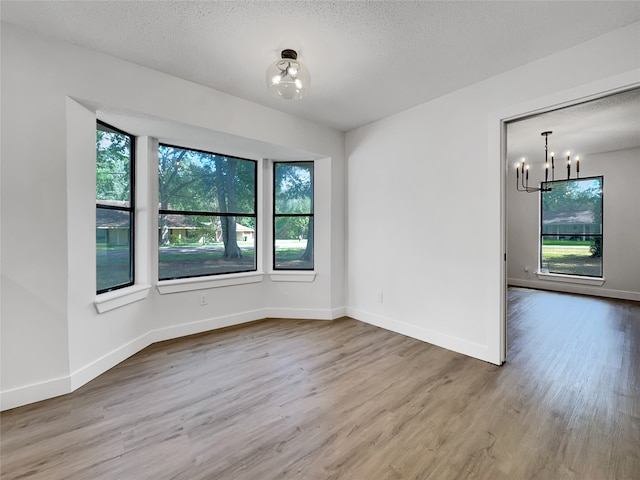 unfurnished dining area featuring a wealth of natural light, hardwood / wood-style floors, and a textured ceiling