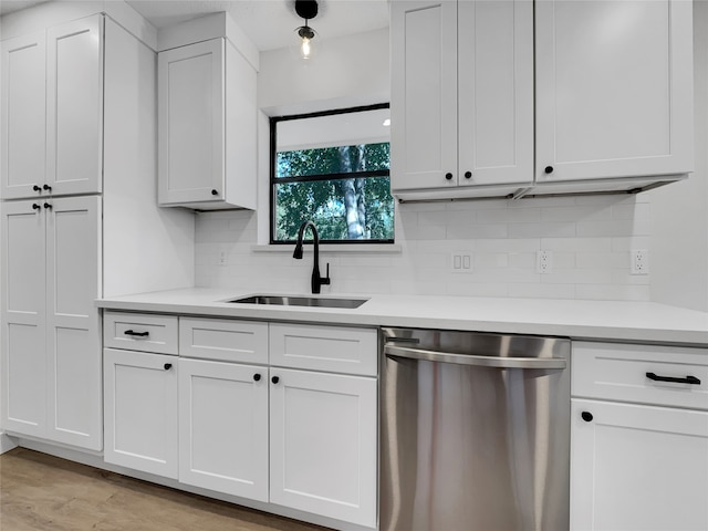 kitchen featuring backsplash, sink, dishwasher, light hardwood / wood-style floors, and white cabinetry