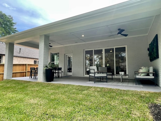 rear view of house with a patio area, ceiling fan, a yard, and an outdoor living space