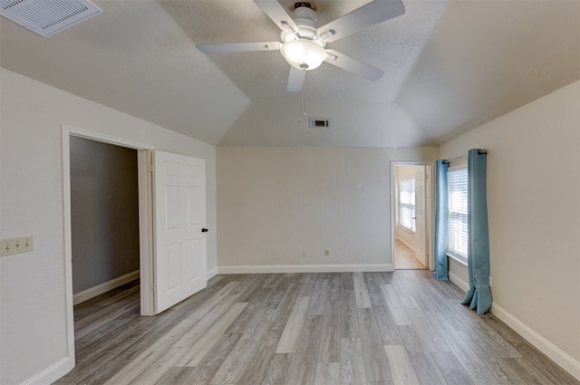 unfurnished bedroom with vaulted ceiling, ceiling fan, and light hardwood / wood-style floors