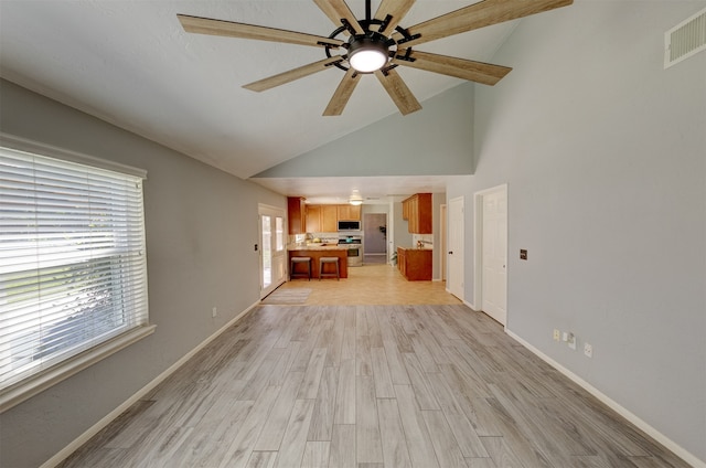 unfurnished living room featuring light hardwood / wood-style floors, high vaulted ceiling, and ceiling fan