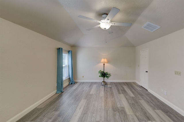 unfurnished room with light hardwood / wood-style floors, vaulted ceiling, and ceiling fan