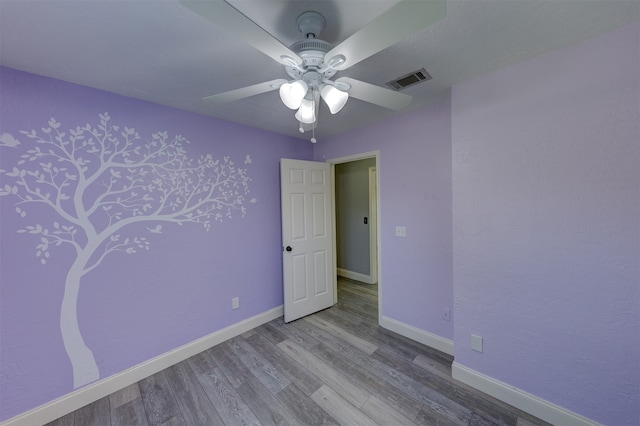 empty room with ceiling fan and light hardwood / wood-style floors