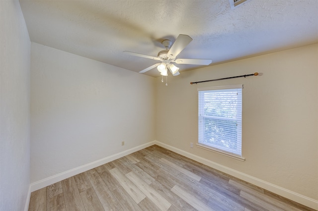 spare room featuring ceiling fan, light hardwood / wood-style floors, and a textured ceiling