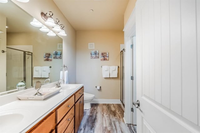 bathroom with an enclosed shower, hardwood / wood-style floors, toilet, and vanity