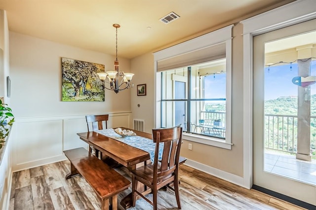 dining space with a chandelier, light wood-type flooring, and plenty of natural light