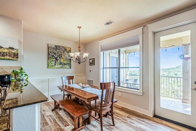 dining room with light hardwood / wood-style flooring and a notable chandelier