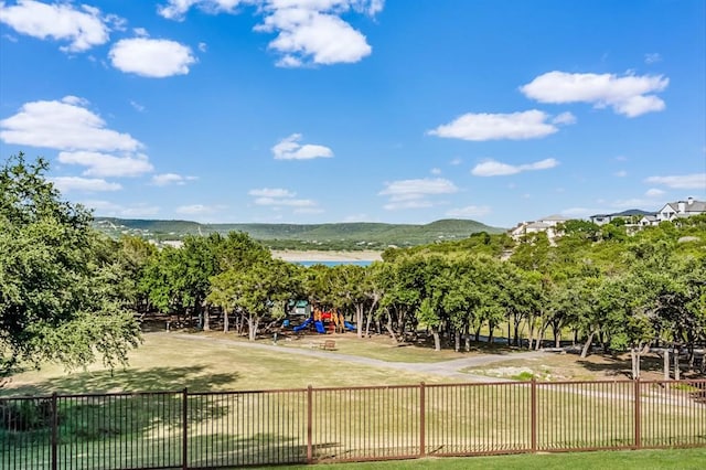 view of community featuring a mountain view, a playground, and a lawn