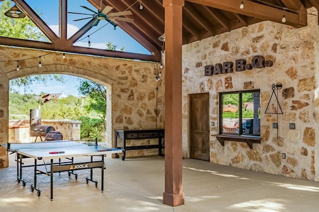 game room with concrete flooring, beamed ceiling, ceiling fan, and high vaulted ceiling