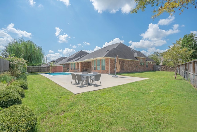 back of property featuring a yard, a fenced in pool, and a patio area