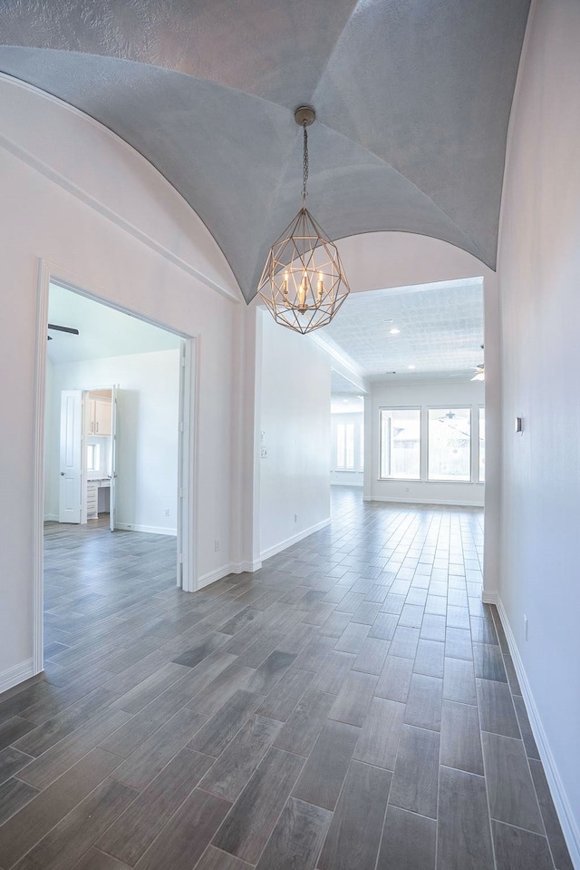 unfurnished room with dark hardwood / wood-style flooring, a chandelier, and vaulted ceiling