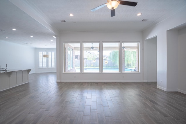 empty room featuring crown molding, sink, ceiling fan with notable chandelier, and dark hardwood / wood-style floors