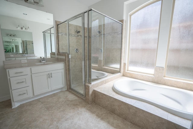 bathroom featuring vanity, independent shower and bath, a healthy amount of sunlight, and tile patterned flooring