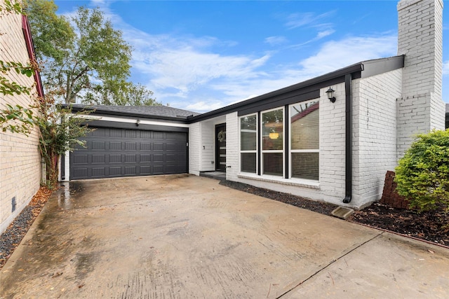 11207 Wood Lodge Dr, Houston, TX 77077 - view of side of home with brick siding, a chimney, a garage, and driveway