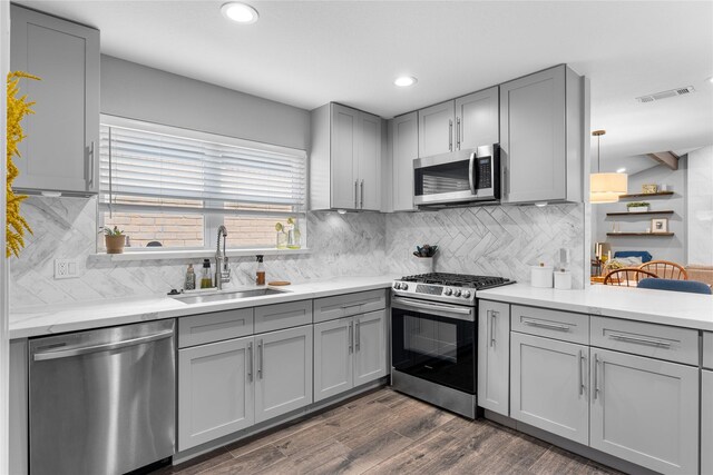 11207 Wood Lodge Dr, Houston, TX 77077 - kitchen featuring appliances with stainless steel finishes, gray cabinets, a sink, dark wood-style flooring, and recessed lighting
