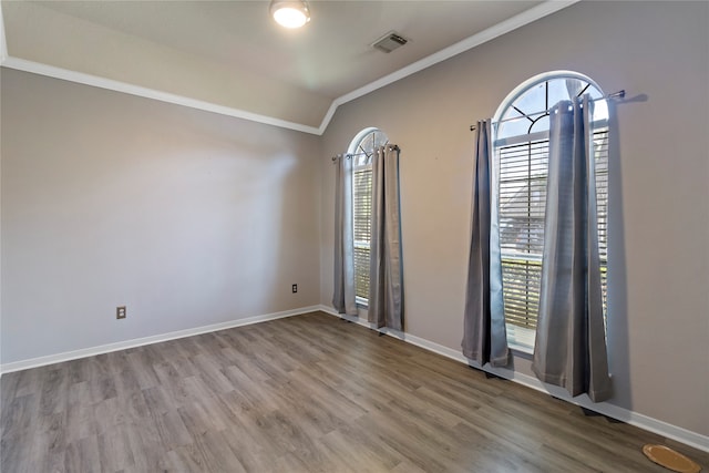 unfurnished room with vaulted ceiling, wood-type flooring, and crown molding