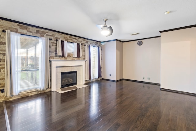 unfurnished living room featuring crown molding, a fireplace, and dark hardwood / wood-style floors