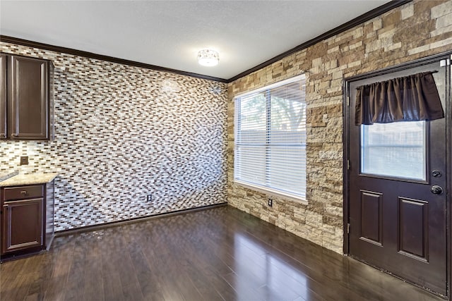 unfurnished dining area with dark hardwood / wood-style flooring and ornamental molding