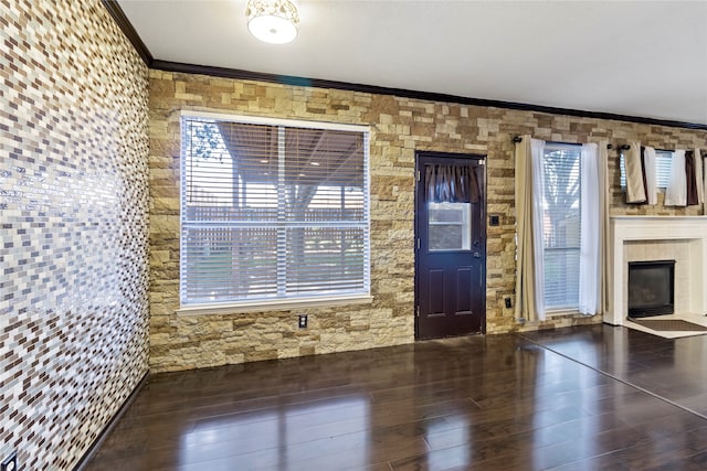 entryway featuring a fireplace, dark hardwood / wood-style flooring, and ornamental molding