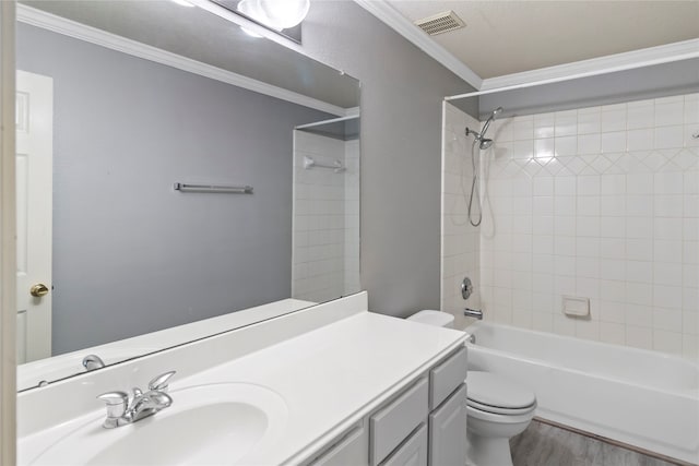 full bathroom with ornamental molding, tiled shower / bath combo, vanity, toilet, and wood-type flooring