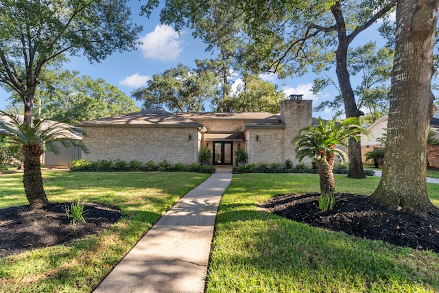 ranch-style house with a front yard and french doors