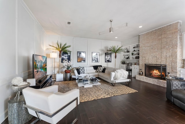 living room featuring a fireplace, dark hardwood / wood-style floors, and built in features