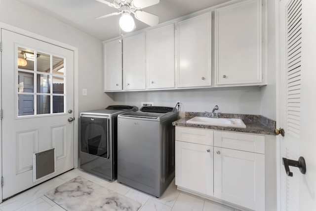 washroom featuring cabinets, sink, ceiling fan, and washing machine and clothes dryer