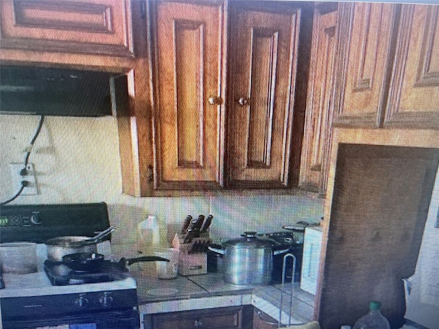 kitchen with decorative backsplash and black range