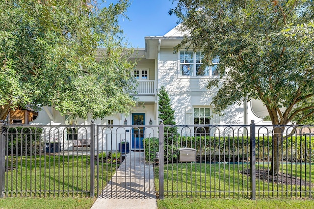 view of front of house with a balcony and a front yard