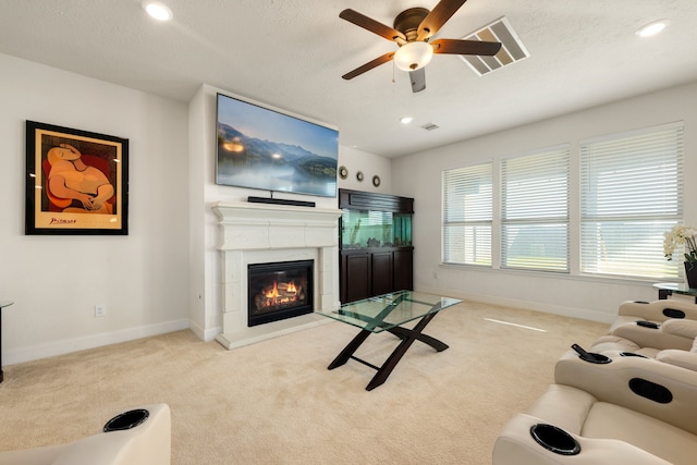 carpeted living room with a textured ceiling and ceiling fan