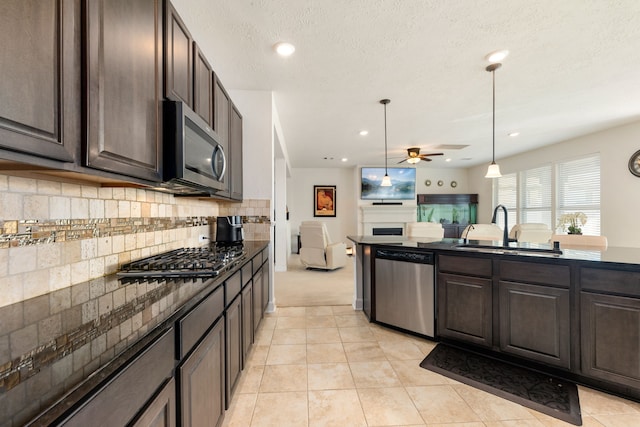 kitchen with backsplash, sink, appliances with stainless steel finishes, and dark brown cabinets