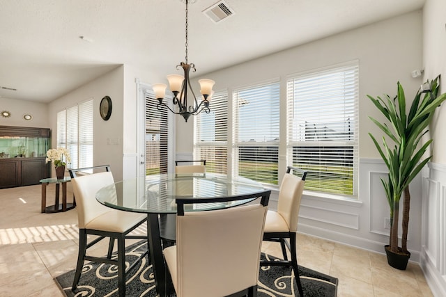 dining space featuring a wealth of natural light, light tile patterned floors, and an inviting chandelier