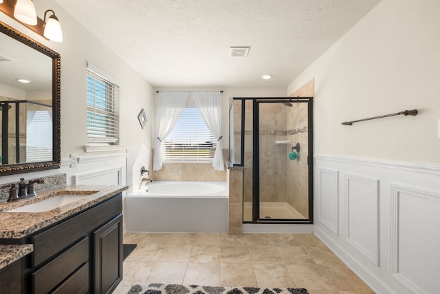 bathroom featuring vanity, shower with separate bathtub, a textured ceiling, and tile patterned floors