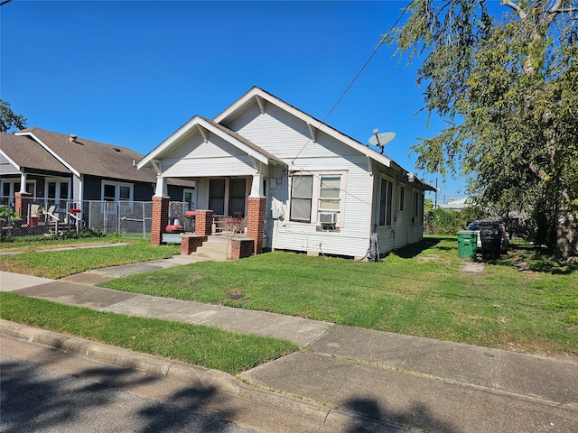 view of front of property featuring cooling unit, a front lawn, and covered porch