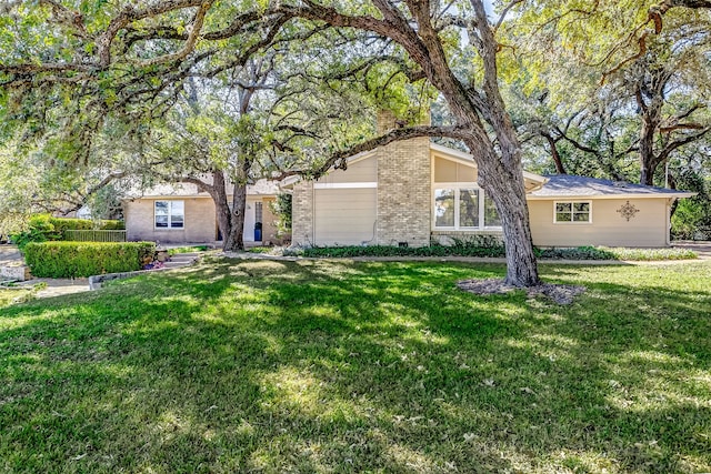 ranch-style house featuring a garage and a front lawn