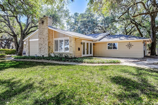 single story home featuring french doors and a front lawn