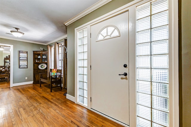 foyer entrance with hardwood / wood-style floors and ornamental molding