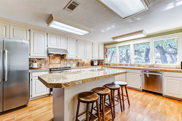 kitchen with white cabinetry, appliances with stainless steel finishes, and a kitchen island