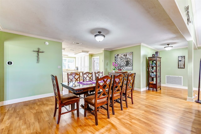 dining area featuring light hardwood / wood-style floors and ornamental molding