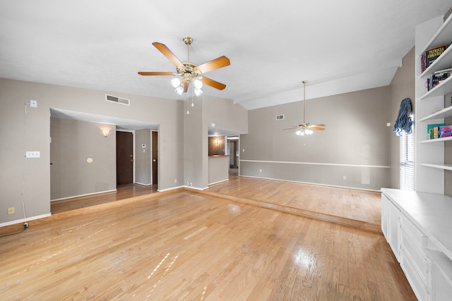 unfurnished living room with ceiling fan, lofted ceiling, and light wood-type flooring