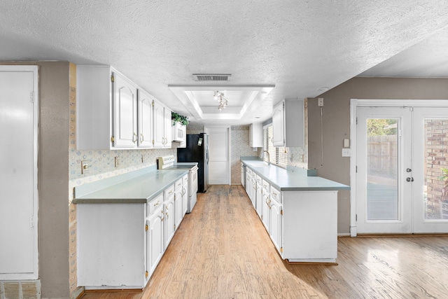 kitchen with white cabinets, light wood-type flooring, white appliances, and french doors